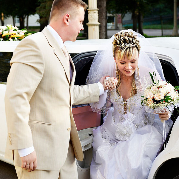Жених помогает невесте выйти из машины